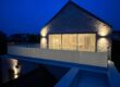 Image of a newly installed frameless glass balcony in Rhosneigr, Anglesey, featuring 21.5mm toughened laminated glass with partial frosting, overlooking a scenic coastal view