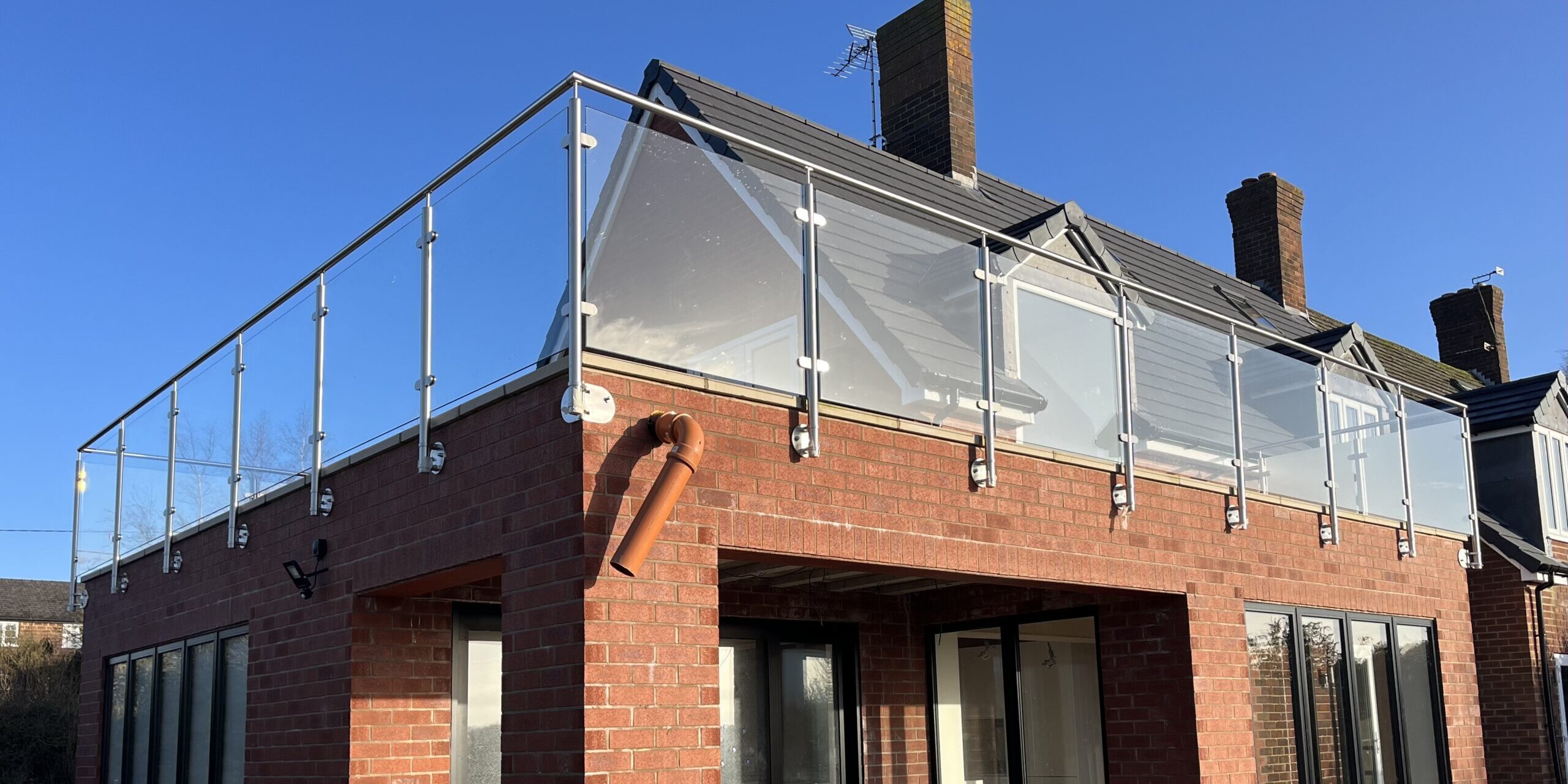 image0 Close-up view of a side-mounted stainless steel glass balustrade, showcasing durable spigots and toughened glass for a secure, modern design.