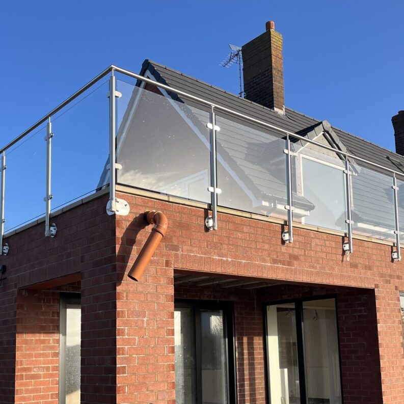 image0 Close-up view of a side-mounted stainless steel glass balustrade, showcasing durable spigots and toughened glass for a secure, modern design.