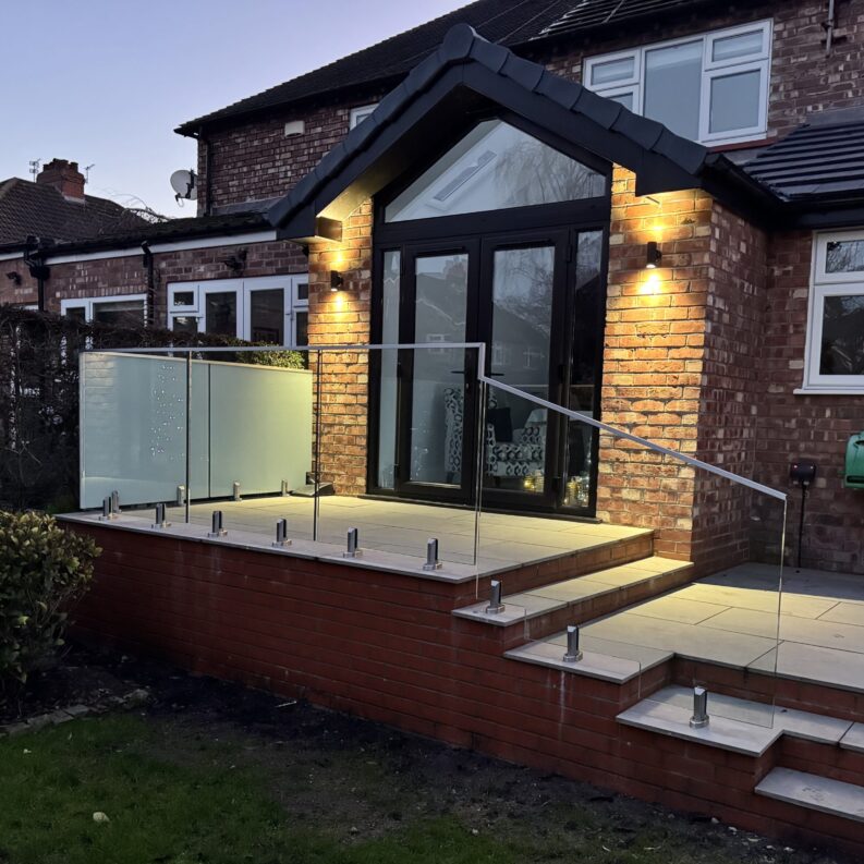 Frameless Glass Balustrade Frameless glass balustrade installed on a garden patio in Altrincham, featuring 17.5mm toughened laminated glass and stainless steel spigots.