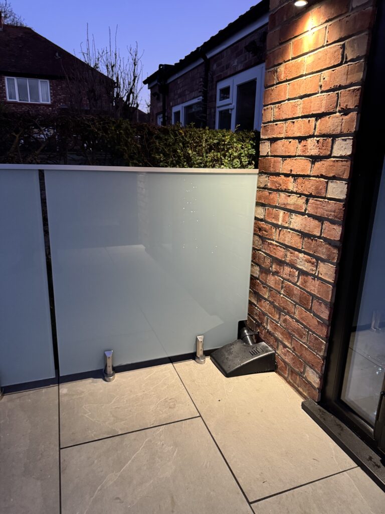 Side angle of the spigot-mounted glass balustrade, highlighting the seamless edge alignment and unobstructed garden views.