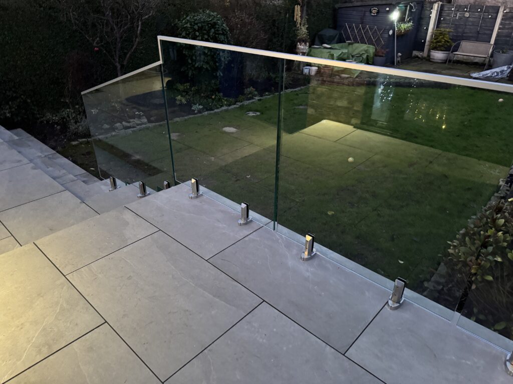 Close-up view of 316 stainless steel spigots securely holding a clear glass panel in place, showcasing the minimalist design and quality finish