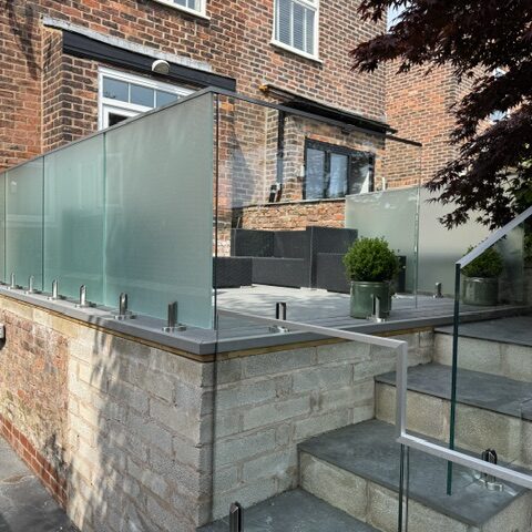 IMG_8934 Glass balustrade installation in Salford featuring 17.5mm toughened laminated glass panels with structural spigots and aluminium capping rail by NW Fabrications