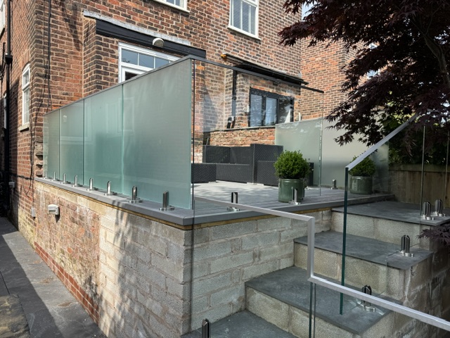 IMG_8934 Glass balustrade installation in Salford featuring 17.5mm toughened laminated glass panels with structural spigots and aluminium capping rail by NW Fabrications