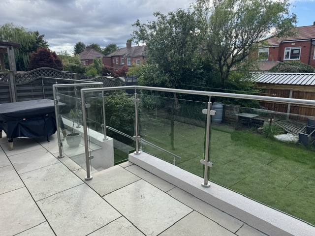 Self-closing glass gate with magnetic latch detail showing stainless steel frame construction