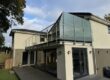 Glass balustrade roof terrace with opaque privacy panels and clear glass sections overlooking garden in Manchester area